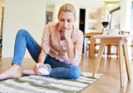 Frau entfernt Rotweinflecken mit Salz aus dem Teppich